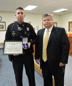 Aston Police Chief Dan Ruggieri (right) presented Officer Joshua Micun with a plaque of commendation for his heroic actions.