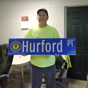 Aston Township Public Works Department Supervisor Russell Palmore displays one of the new street signs bearing the township logo.